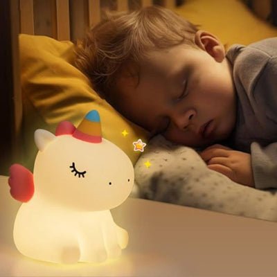 Bébé dort paisiblement, éclairé par sa bébé veilleuse UniLight™ en forme de licorne