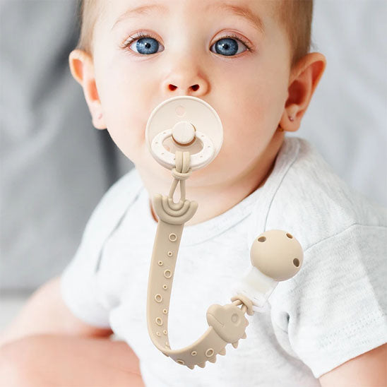 attache tétine en silicone bébé assit