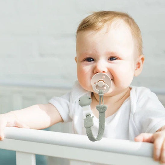 Bébé debout dans le lit attache tétine en silicone