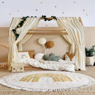 Un ciel de lit cabane blanc cassé suspendu au-dessus du lit crée une atmosphère douce et apaisante dans la chambre