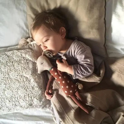 enfant allonge dans le lit avec son doudou ptit reveur