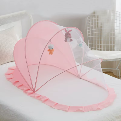 Une moustiquaire pour lit bébé légère rose pastel est déployée sur le lit pour protéger et apaiser le tout-petit