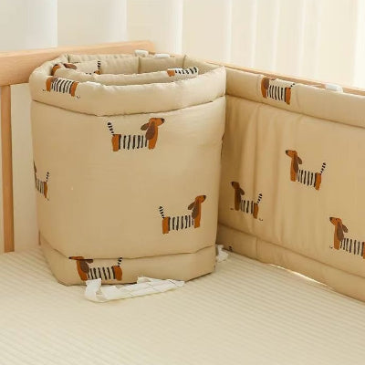 Un tour de lit bebe souple beige décoré de petits chiens