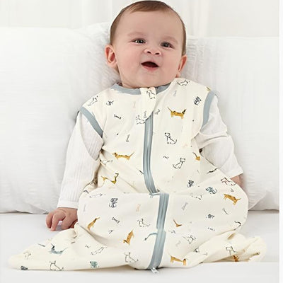 Assis confortablement, un bébé souriant porte une gigoteuse sans manches aux adorables motifs de teckels.