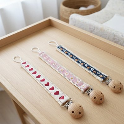 Attache tetines : blanc motif cœur, rose motif fleur de marguerite, bleu foncé motif fleurs
