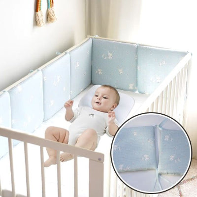 Autour de bébé allongé, un tour de lit bébé complet bleu rembourré aux motifs d’éléphants agrémenté de petites étoiles et de lignes pointillées garantit un espace cosy et sûr.
