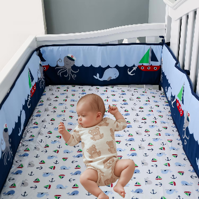 Bébé allonge dans son lit est entouré d'un tour de lit bebe garcon décoré de bateaux, d'animaux marins et de vagues offrant un espace sécurisé et ludique