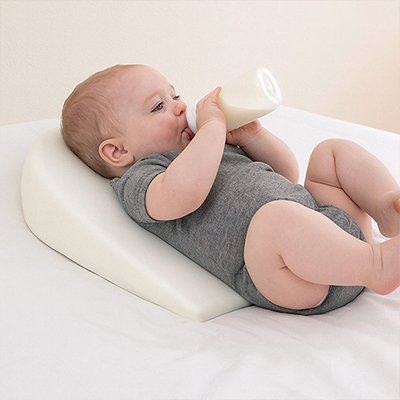  Bébé allongé sur le dos buvant son biberon sur un plan incliné bébé Anti-Reflux 15° DreamerBaby™ blanc