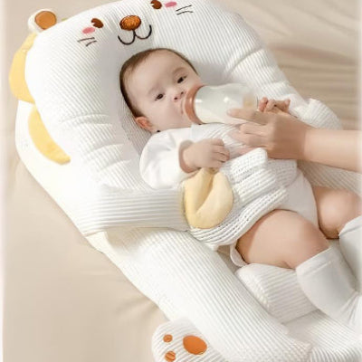  Bébé boit son lait, installé dans son reducteur de lit bebe HeatPad™