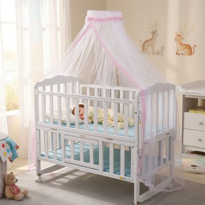 Bébé endormi dans son lit, enveloppé par sa moustiquaire pour lit bébé suspendue au-dessus du lit.