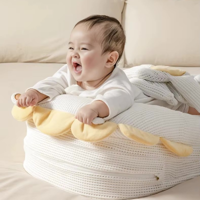  Bébé, tout sourire sur le ventre, bien installé dans son reducteur de lit bebe HeatPad™