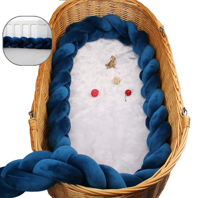 Dans un panier en osier raffine, une tresse de lit cabane bleu marine compose un véritable nid chaleureux pour le confort du bébé.