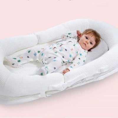Enfant allongé dans son reducteur de lit bebe WeedgePood™ blanc