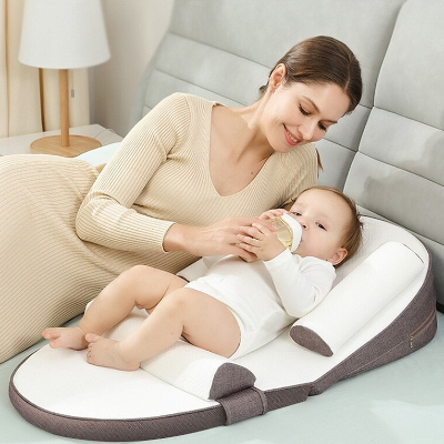  La maman donne le biberon à son bébé, qui est bien installé sur son cale pour bebe StarrySlumber™ marron