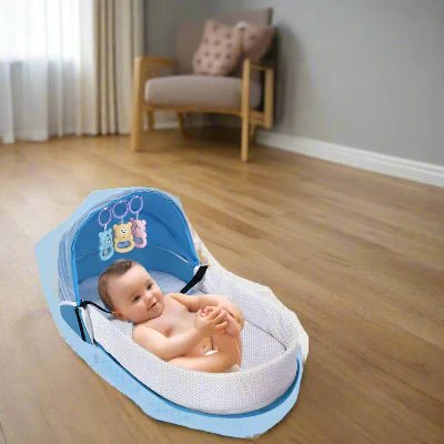Le bébé allongé dans son Berceau de Voyage BabyNest™ Bleu déposé sur le sol