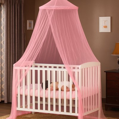 Sous la moustiquaire ciel de lit bébé rose suspendue au-dessus du lit, le bébé dort paisiblement, bercé dans un cocon de douceur et de sécurité.