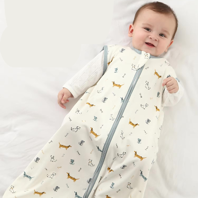Un bébé souriant repose paisiblement sur un lit, enveloppé dans une gigoteuse sans manches décorée de petits teckels.