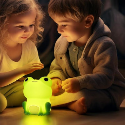 assis côte à côte, une fille et un garçon s’amusent avec leur veilleuse bébé placée devant eux