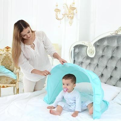 Avec un geste tendre, maman ouvre la moustiquaire pour lit bebe et le bébé s’éveille, assis sur le lit, prêt pour la journée.
