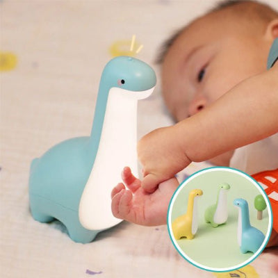 Bébé allongé regarde veilleuse dino rex