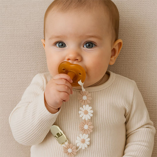 Bébé assis attache sucette floral