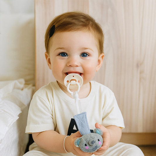 Bébé assis attache tétine éléphant