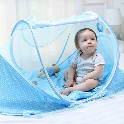 Bébé assit dans le lit moustiquaire bébé doudou sur le côté