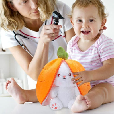 bébé est chez le pédiatre pour sa visite, son lapin doudou posé juste devant lui
