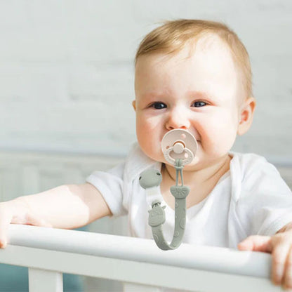 Bébé debout dans le lit attache tétine en silicone