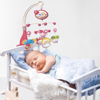 Bébé endormi dans son lit mobile musical bébé rose