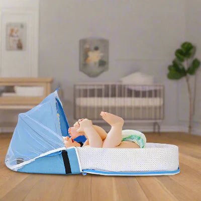 Le bébé est allongé dans son Berceau de Voyage BabyNest™ Bleu est déposé par terre