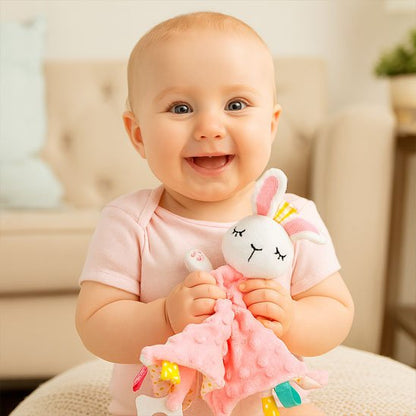 Bébé souriant dans ses mains son doudou bébé lapin