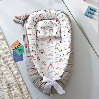 Berceau Bébé NidPortableBébé™ Arc En Ciel est déposé sur le canapé
