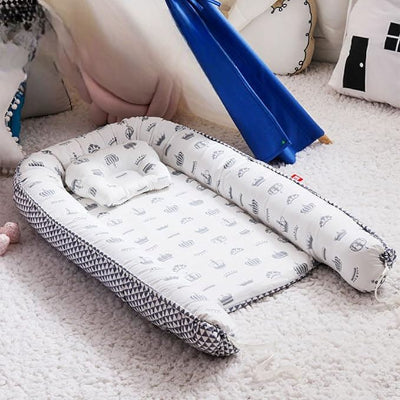 Berceau Bébé NidPortableBébé™ Couronne déposé sur le tapis blanc