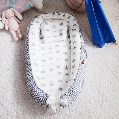 Berceau Bébé NidPortableBébé™ Couronne est déposé sur le tapis