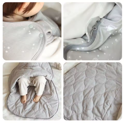 Les détails de la gigoteuse grise à motifs d’étoiles et de montgolfières