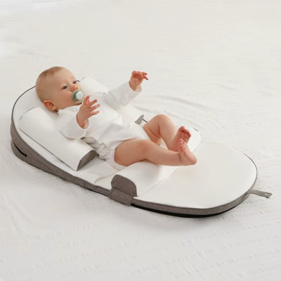 enfant allongé sur un cale pour bebe StarrySlumber™ de couleur marron.