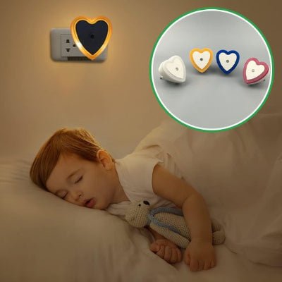 Un enfant s'est endormi paisiblement, son doudou entre les bras, sous la lumière de sa veilleuse murale bebe DreamNight™ en forme de cœur.