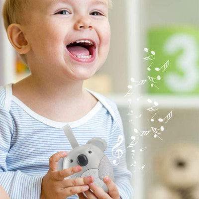 Enfant souriant sa veilleuse bruit blanc dans ses mains