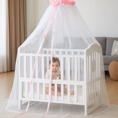 fillette assit dans le lit avec son doudou moustiquaires lit bébé