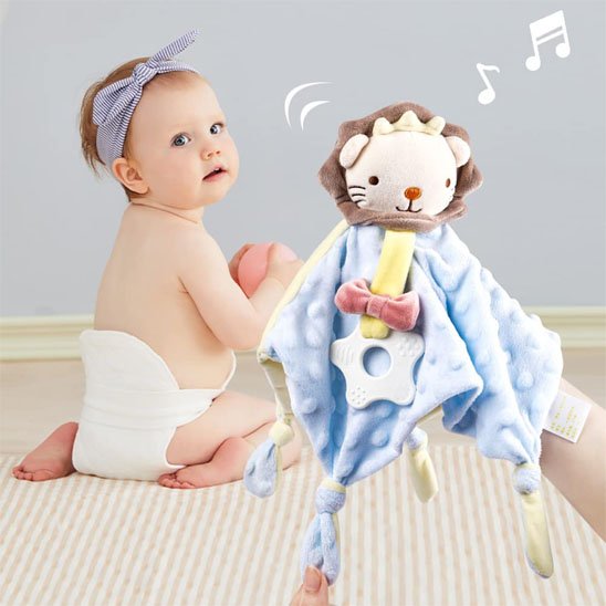 Fillette assit et regarde son doudou bébé lion dans la main