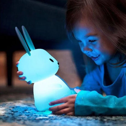 La fillette joue en changeant la couleur de la veilleuse bébé Glowbit™ 