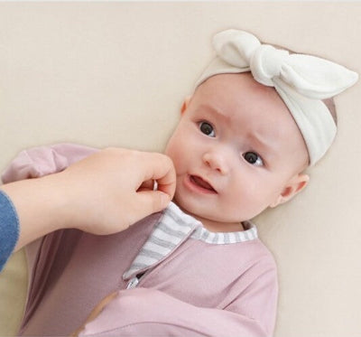 Une fillette paisible, enveloppée dans une douce gigoteuse emmalliotage violette