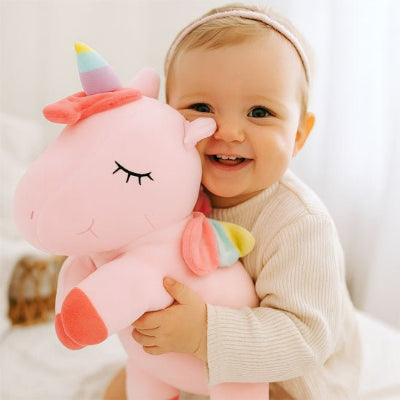 fillette sert son doudou licorne avec un grand sourire