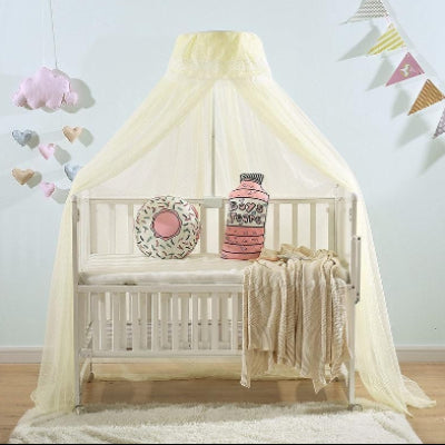 Une fine moustiquaire de lit jaune enveloppe délicatement le lit bébé créant une atmosphère douce et paisible dans la chambre lumineuse