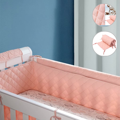 Un lit bébé est amenage avec un tour de lit bébé fille matelasse rose créant un espace doux et chaleureux