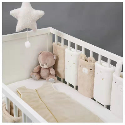 Le lit bébé blanc est habillé d’un tour de lit modulable aux coussinets ourson et lapin, offrant un cocon doux et ludique parfaitement coordonné au reste du linge.