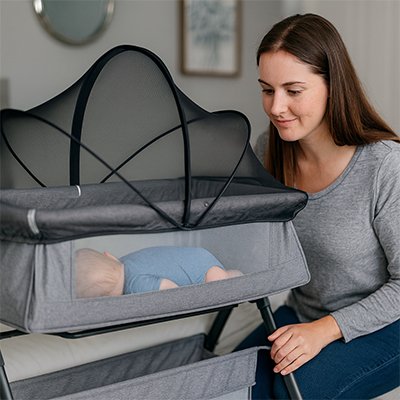 maman regarde sa fillette endormie dans le lit moustiquaire lit bébé