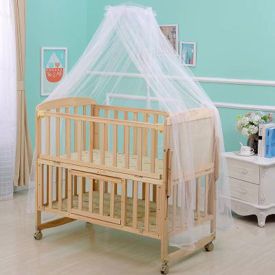 Une moustiquaire lit blanche et légère tombe en voile autour d'un lit bébé en bois