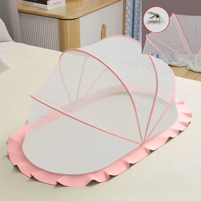 Une moustiquaire pour lit bébé de couleur rose en forme de dôme avec un voilage fin est posée sur un lit pour offrir un espace protégé et doux au nourrisson.